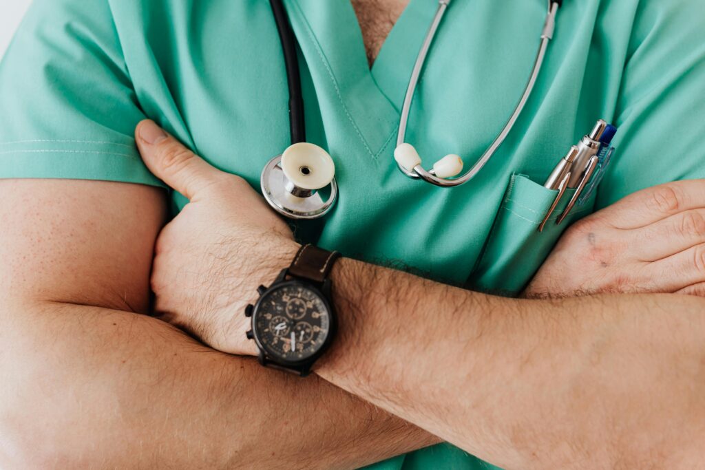 pexels-photo-4021775-4021775 Close-up of a healthcare professional with arms crossed wearing medical scrubs and stethoscope.