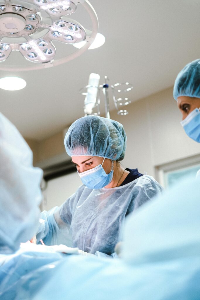 pexels-photo-4421494-4421494 A team of surgeons and nurses in protective gear performing an operation in a hospital.