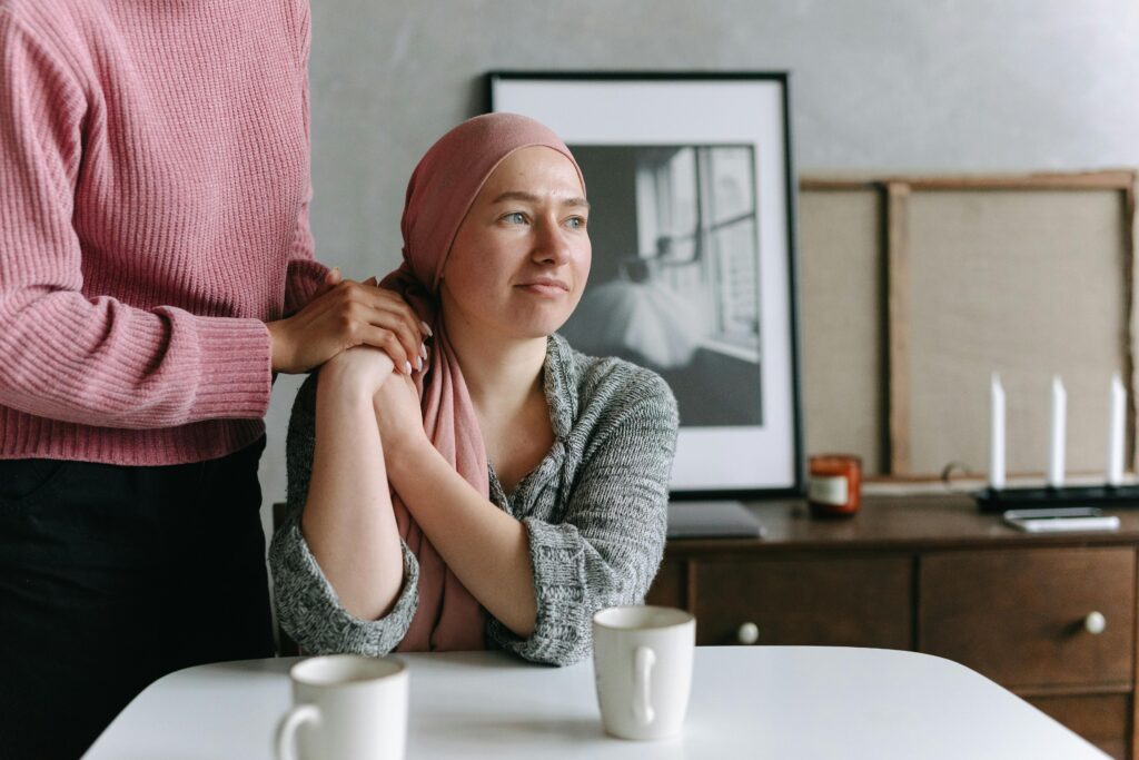 pexels-photo-7659552-7659552 A supportive moment indoors featuring a cancer patient comforted by a friend, conveying emotion and care.